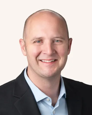 Headshot of a man smiling in a suit